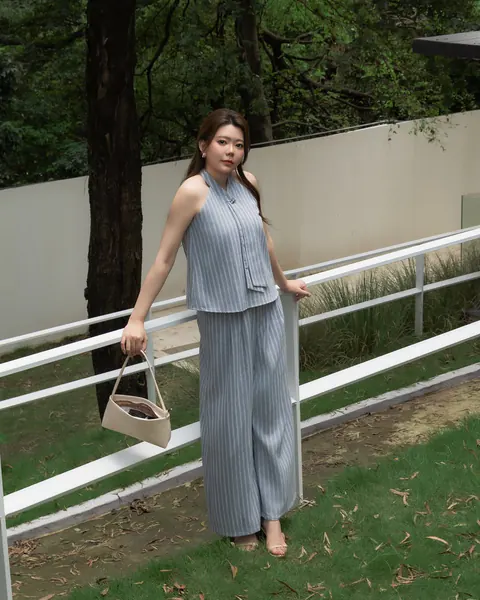 Woman wearing a grey sleeveless MUSII look outdoors